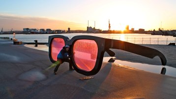 Ein Mann steht in einer riesigen Brille, im Hintergrund scheint die Sonne (Image: TH Köln / Philipp Ant)