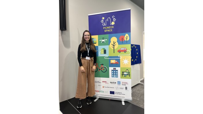 Dieses Bild zeigt Lisa Reissner von der TH Köln vor einem Roll-UP der PIONEER Alliance.