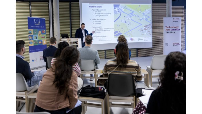 Prof. Dr. Christian Wolf, Vizepräsident für Digitalität und Nachhaltigkeit an der TH Köln, hält Vortrag zu Klimawandelauswirkungen wie Starkregen und Dürren auf die Stadt Köln.
