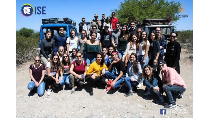 Eine Gruppe von Studierenden steht vor zwei Jeeps in Mexiko und lächelt in die Kamera. 