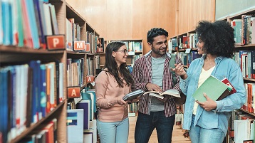 Drei Studierende unterhalten sich in der Bibliothek (Image: iStock)