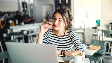 Frau überdenkt bei einer Tasse Kaffee am PC ihre Situation (Bild: istock)