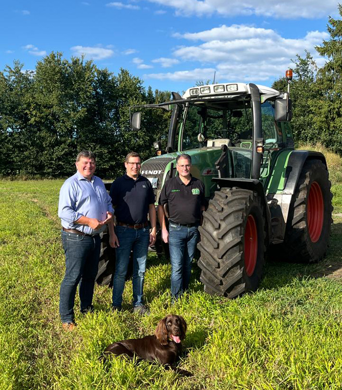 Hennung Ester mit Vater Stefan und Onkel Markus neben einem Traktor
