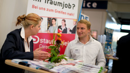 Eine Frau und ein Mann unterhalten sich an einem Messestand Eine Frau und ein Mann unterhalten sich an einem Messestand