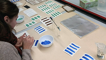 Im Rahmen eines Seminars werden verschiedenfarbige Aufstriche auf Papier hergestellt, um sie mit verschiedenen Geräten zu bearbeiten. Es werden sowohl Pastellkreide als auch Pigmentaufstriche angefertigt. Im Hintergrund sieht man ein Gerät, welches zur Anwednung kommt. (Bild: TH Koeln - CICS - Andrea Pataki-Hundt)