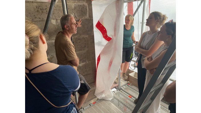 Ume Schäfer erläutert die Vorgehensweise bei den Restaurierungsarbeiten an der Außenfassade des Chores.