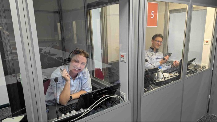 Personen arbeiten in den Dolmetschkabinen des ITMK