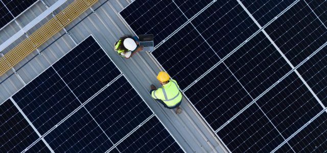 Zwei Ingenieur*innen arbeiten an einer PV-Anlage auf einem Dach  (Bild:Adobe Stock/Eakarat)