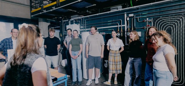 Studierende stehen im Wärmepumpenlabor und hören der Professorin zu (Bild:Thilo Schmülgen/TH Köln)