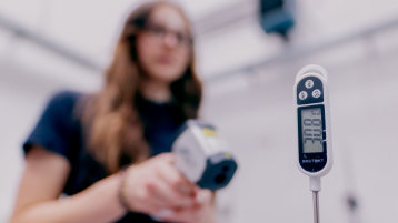 Studierende im Labor für Korrosion und neue Werkstoffe: Kontaktlose Bestimmung der Temperatur mit Pyrometer (Bild: Thilo Schmülgen/TH Köln)