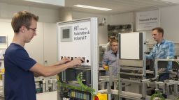 Drei Studierende bedienen Schalter und Apparaturen in einer Modellanlage für flexible Fertigung (Image: Thilo Schmülgen/FH Köln)