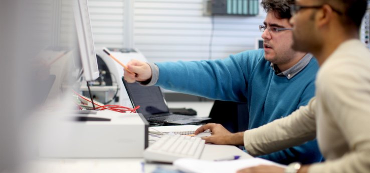 Ein Studierender zeigt einem anderen Studierenden etwas an einem Computer-Monitor (Bild: Thilo Schmülgen/TH Köln)