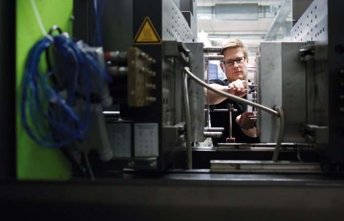 Studierender an der Kunststoff-Spritzgussmaschine Studierender an der Kunststoff-Spritzgussmaschine