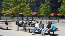 Studierende auf Bänken und Stühlen im Freien vor Bäumen auf einem Platz vor der Hochschule (Image: Manfred Stern/FH Köln)