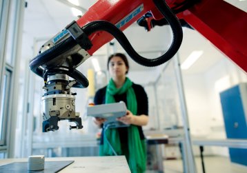 Studentin bedient einen Industrieroboter Studentin bedient einen Industrieroboter