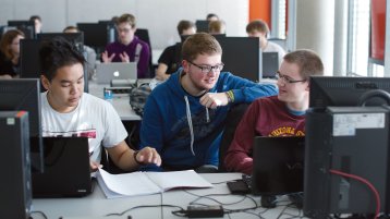 Sieben Studierende sitzen in einem PC-Pool an Monitoren (Bild: Schmülgen/FH Köln)