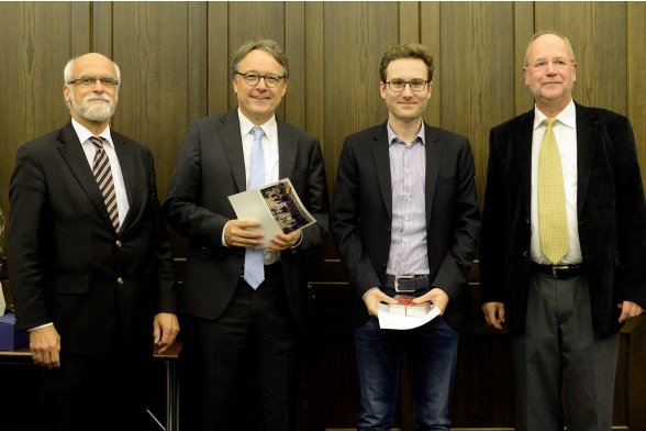 Gruppenfoto mit Professor Jochen Axer, Professor Karl Maier und Professor Peter Schimikowski mit einem Absolventen