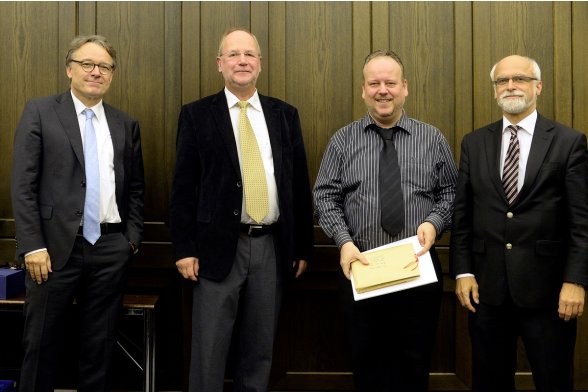 Gruppenfoto mit Professor Karl Maier, Professor Peter Schimikowski und Professor Jochen Axer mit einem Absolventen