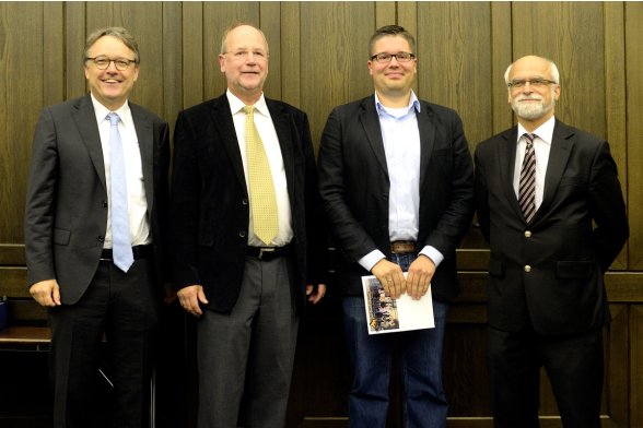 Gruppenfoto mit Professor Karl Maier, Professor Peter Schimikowski und Professor Jochen Axer mit einem Absolventen