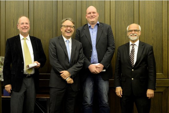 Gruppenfoto mit Professor Peter Schimikowski, Professor Karl Maier und Professor Jochen Axer mit einem Absolventen