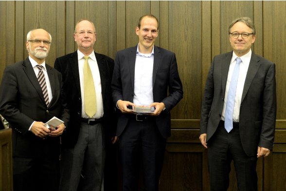 Gruppenfoto mit Professor Jochen Axer, Professor Peter Schimikowski und Professor Karl Maier mit einem Absolventen