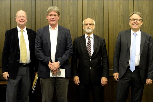 Gruppenfoto mit Professor Peter Schimikowski, Professor Jochen Axer und Professor Karl Maier mit einem Absolventen