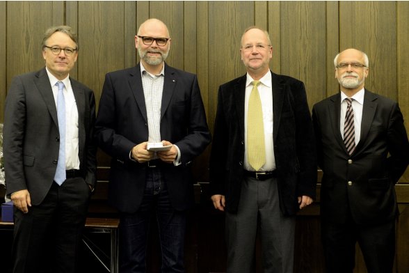 Gruppenfoto mit Professor Karl Maier, Professor Peter Schimikowski und Professor Jochen Axer mit einem Absolventen