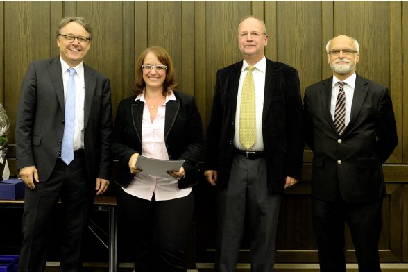 Gruppenfoto mit Professor Karl Maier, Professor Peter Schimikowski und Professor Jochen Axer mit einer Absolventin