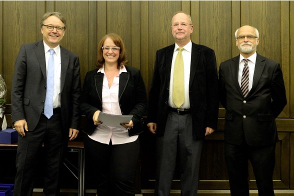 Gruppenfoto mit Professor Karl Maier, Professor Peter Schimikowski und Professor Jochen Axer mit einer Absolventin