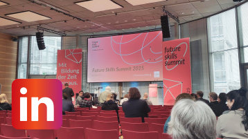 Roll-Ups mit dem Slogan "Mit Bildung der Zukunft voraus" rahmen einen Präsentationsbildschirm im Veranstaltungsraum in Berlin (Bild: TH Köln)