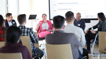 Die Referent:innen des XR-Learning Days sitzen in einem Halbkreis vor den Teilnehmenden. (Bild: TH Köln)