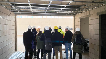 Die Teilnehmerinnen und Teilnehmerinnen des Lehrgangs Baugenehmigungsanagement besuchen einen Schulneubau (Bild: Akademie für wissenschaftliche Weiterbildung der TH Köln)