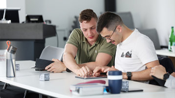 Zwei Weiterbildungsteilnehmende besprechen sich über die Inhalte auf einem iPad. (Bild: TH Köln)