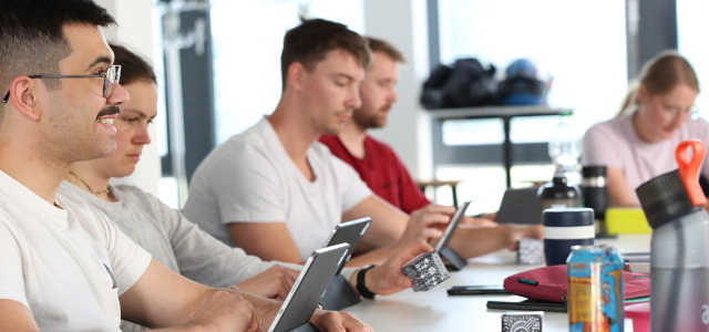 Seminarteilnehmende sitzen in einer lockeren Reihe und erkunden Inhalte auf iPads. (Bild:TH Köln)
