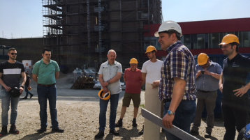 Dozent Lutz Krüger zeigt den Teilnehmer*innen die Eigenschaften von Gipskarton-Feuerschutzplatten auf der Baustelle des Universitätsklinikums Düsseldorf (Bild: TH Köln)