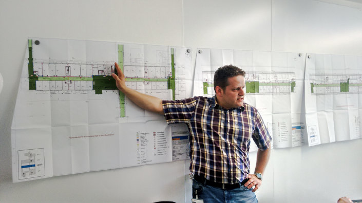 Lutz Krüger erläutert die Planunterlagen zum Brandschutzkonzept des Gebäudes.