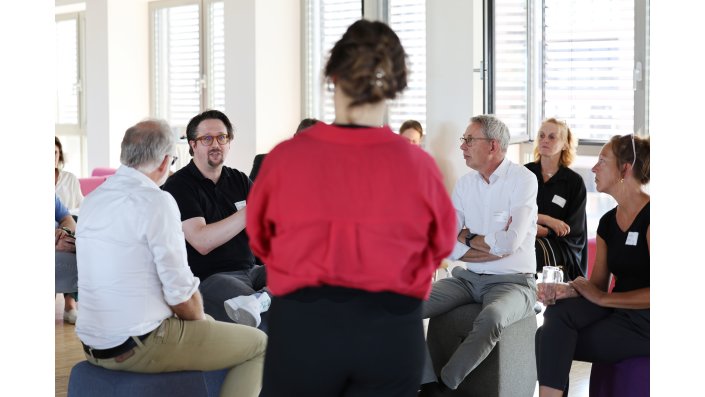 Eine kleine Gruppe diskutiert im Innenkreis der Fish Bowl.