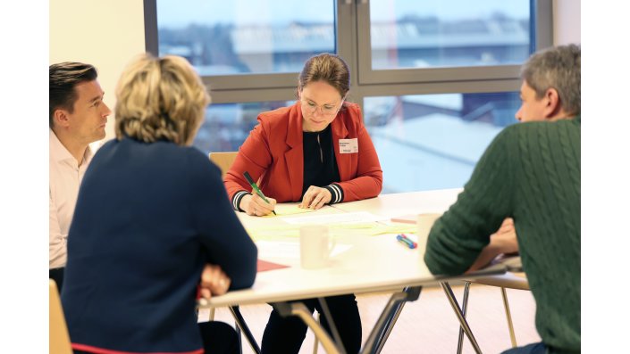 In einer weiteren Arbeitsgruppe schreibt eine Dame die Anregungen auf bunte Zettel.