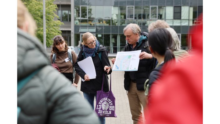Dr. Verena Dlugoß der Universität Köln zeigt auf eine Karte, die Klimadaten enthält.