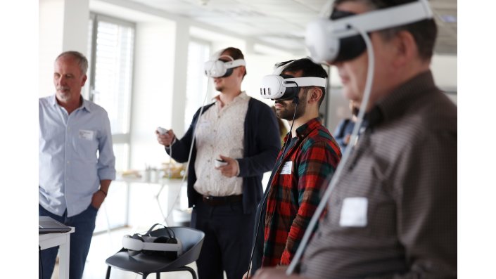 Drei Männer mit VR-Brillen testen im Multiplay-Modus die virtuelle Fabrik.