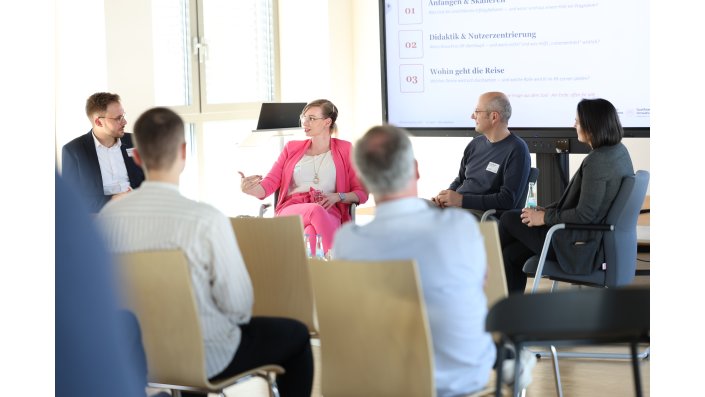 Die Referent:innen des Tages sitzen auf Armlehnstühlen in einem Halbkreis.