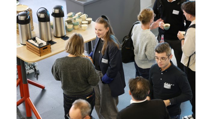 Mehrere Personen unterhalten sich in Grüppchen.