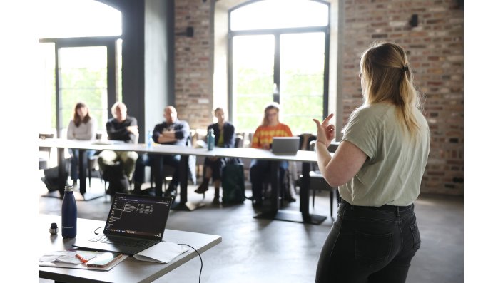 Anna Jo Merk referiert im Seminarraum vor der Gruppe.